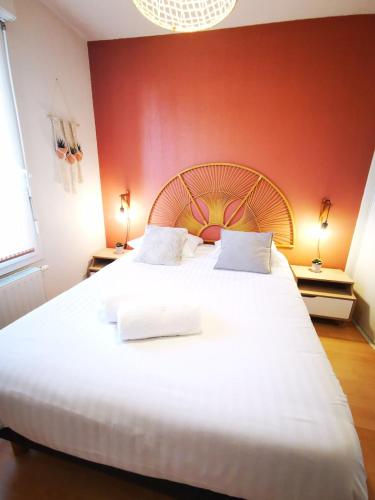 a bedroom with a large white bed with a red wall at Chez Manue et Ludo centre ville in Thonon-les-Bains