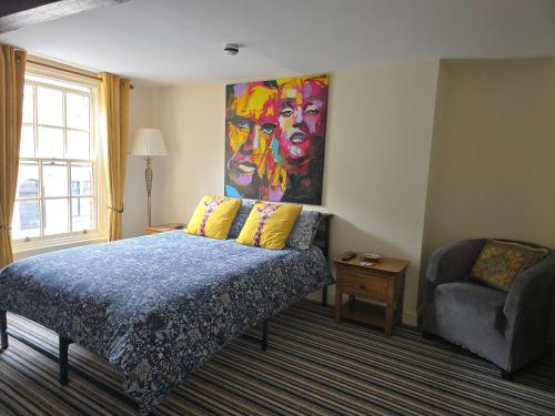 a bedroom with a bed and a painting on the wall at Unicorn Hotel Llanidloes in Llanidloes
