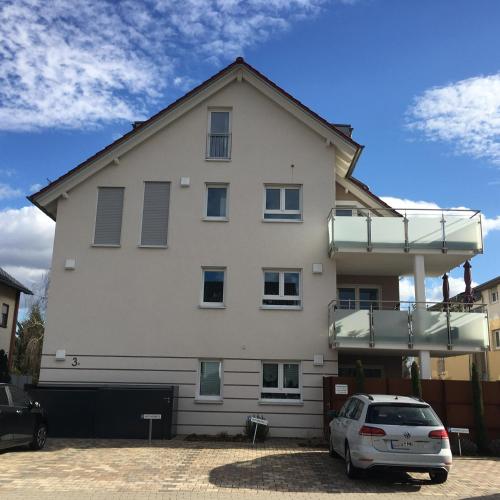 a white building with a car parked in front at Weinreisedomizil mit eigenem Garten und Parkplatz in Deidesheim