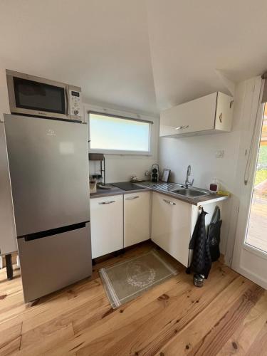 a small kitchen with a refrigerator and a microwave at Gites Colline De Sollies in Salernes