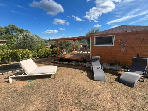 a backyard with two lounge chairs and a house at Gites Colline De Sollies in Salernes