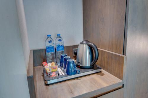 a shelf with two bottles of water and a coffee maker at Howard Johnson Plaza by Wyndham Dubai Deira in Dubai