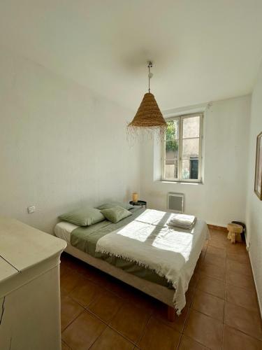 un dormitorio con una cama y una ventana en Large duplex with garden in historic house, en Le Cannet