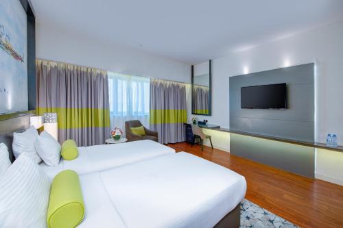 a hotel room with a bed and a flat screen tv at Howard Johnson Plaza by Wyndham Dubai Deira in Dubai