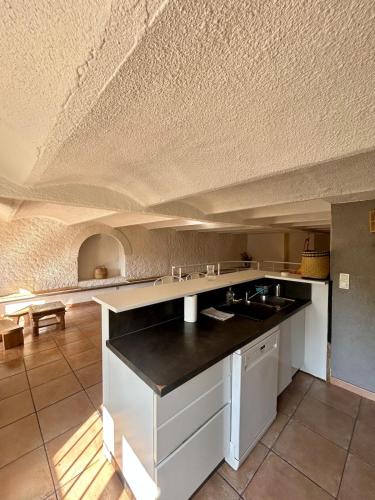 cocina con armarios blancos y techo blanco en Large duplex with garden in historic house, en Le Cannet