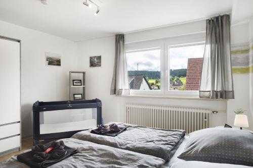a bedroom with two beds and a window at Ferienwohnung Windradblick in Schonach