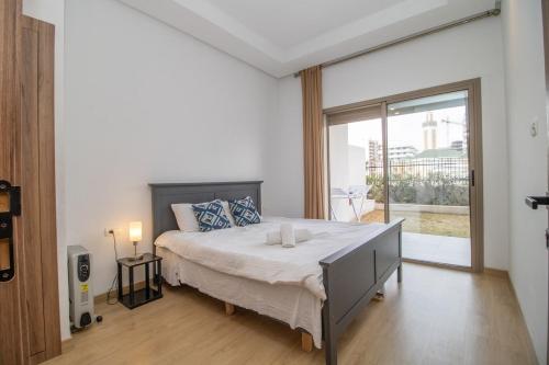 a bedroom with a large bed and a large window at Zenitude in Casablanca