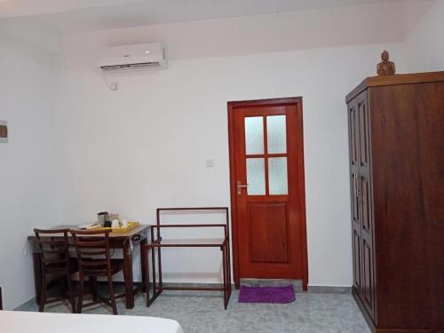 a dining room with a table and a red door at Twins Beach Villa in Moragalla