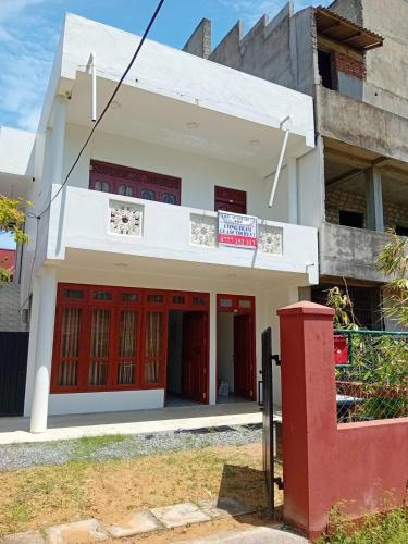 a building with red doors in front of it at Twins Beach Villa in Moragalla