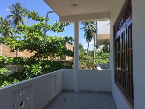 a balcony of a house with a view of a tree at Twins Beach Villa in Moragalla