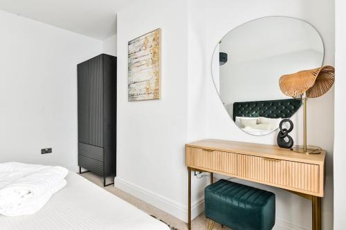 a bedroom with a mirror and a bed and a desk at Stylish House Near Wembley Stadium in London