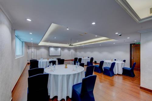 a conference room with tables and chairs and a screen at Howard Johnson Plaza by Wyndham Dubai Deira in Dubai