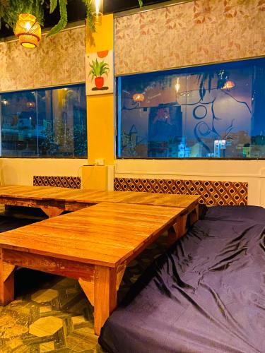 two wooden benches in a room with a window at The Commune Banaras in Varanasi
