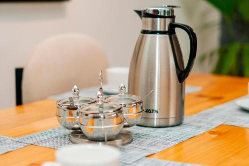 a tea pot and three bowls on a table at Ndare Eco Ville in Kigali