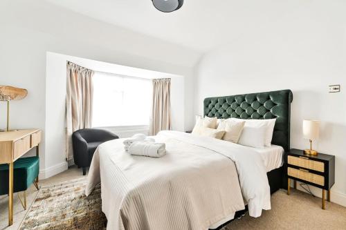 a bedroom with two beds with a green headboard at Stylish House Near Wembley Stadium in London