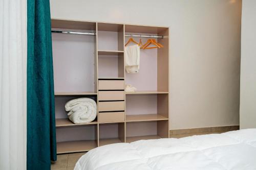 a bedroom with a bed and a closet at Ndare Eco Ville in Kigali