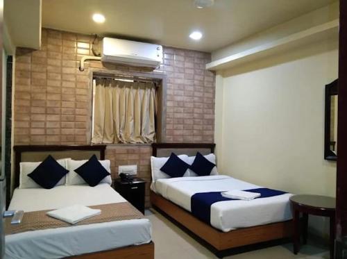 a bedroom with two beds and a window at P A Residency in Mumbai