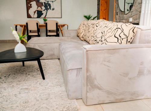 a living room with a white couch and a table at Ndare Eco Ville in Kigali