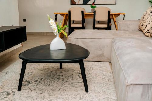 a living room with a vase of flowers on a table at Ndare Eco Ville in Kigali