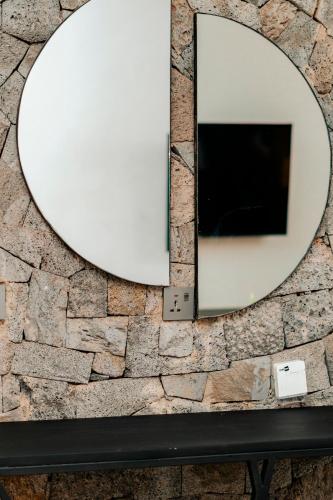 a mirror on top of a stone wall at Ndare Eco Ville in Kigali