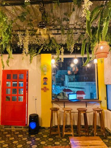 a bar with stools and a red door in a restaurant at The Commune Banaras in Varanasi