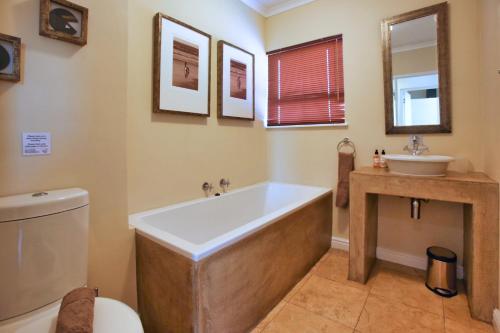 a bathroom with a tub and a sink at Ellefsen Golf Suite 115, Langebaan, 4-sleeper in Langebaan