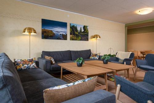 a living room with blue couches and a table at Logi Tuppen, Vandrarhem - Oskarshamns folkhögskola in Oskarshamn