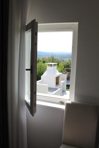 a window with a view of a white building at Vila Conceptt casa in Jasenak