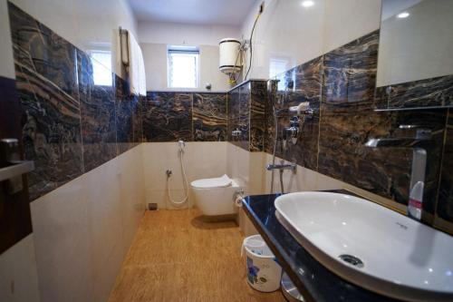 a bathroom with a sink and a toilet at The Royal Sea A Unit of Adi Group of Hotel And Resort in Digha