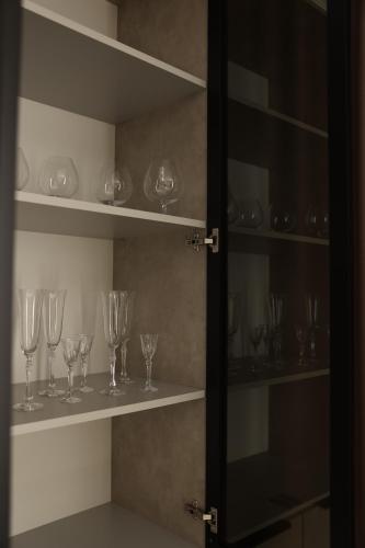 a row of wine glasses sitting on shelves at Hotel France in Vinnytsya