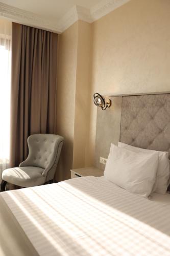 a hotel room with a bed and a chair at Hotel France in Vinnytsya
