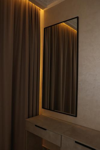 a mirror on top of a dresser with a curtain at Hotel France in Vinnytsya
