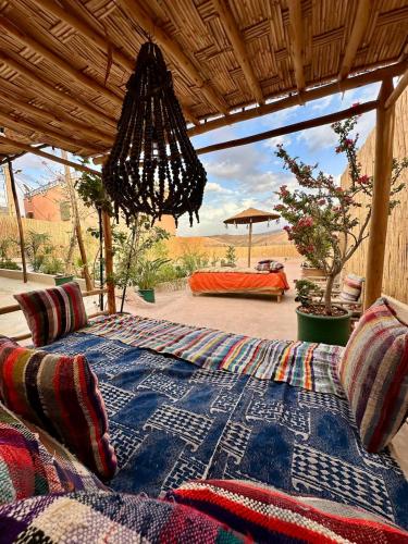 a bed with a blue blanket and pillows on a porch at Kasbah Habibi petit déjeuner inclus in Lalla Takerkoust