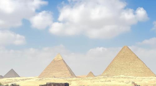 a group of pyramids under a cloudy sky at Flower Pyramids INN in Cairo