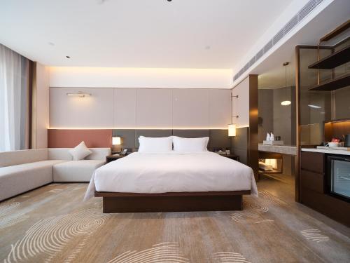 a bedroom with a bed and a couch and a television at SINOKAI International Hotel in Maqifa