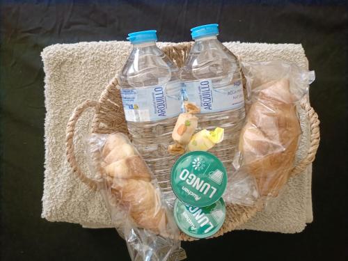 a basket with two bottles of water and bread at Habitaciones Ernesto in Alicante