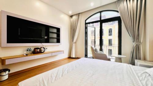 a bedroom with a bed with a tv and a window at The Muse 3 in Ðố Sơn