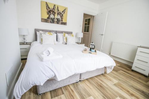 a bedroom with a large bed with white sheets at K Suites - Lake View Apartments in Lowestoft