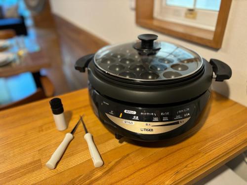 a slow cooker sitting on top of a wooden table at Villa Foresta Sora in Nasushiobara
