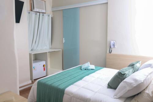 a bedroom with a bed with a green and white blanket at Hotel Esperança AdultOnly in Rio de Janeiro