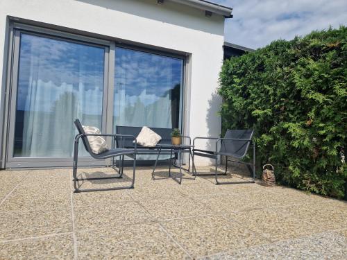 two chairs and a table on a patio at Lakeside Ferienhaus Neusiedl am See in Neusiedl am See