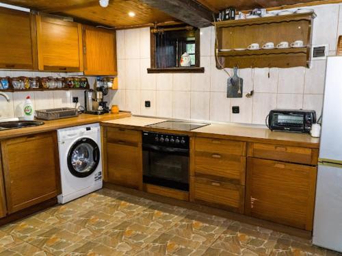 a kitchen with a dishwasher and a washer at Къща за гости Ножери in Tryavna