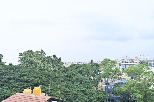 a roof of a building with trees in the background at Hotel Noble Nook, 100 Ft Road, Indiranagar in Bengaluru
