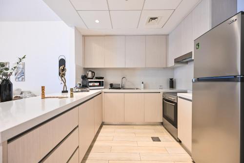 a kitchen with white cabinets and a refrigerator at Chic Family 2br, Canal Views! Near Ferrari World in Abu Dhabi