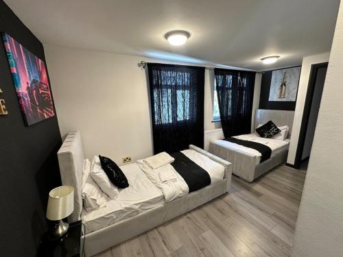 a living room with a couch and a bed at Heathrow Large House with Driveway, Hot tub and Garden in Colnbrook
