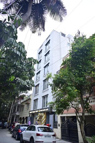 a white car parked in front of a building at Hotel Noble Nook, 100 Ft Road, Indiranagar in Bengaluru