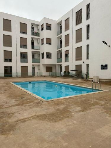 an empty swimming pool in front of a building at Confort moderne avec piscine & Vue panoramique in Agadir