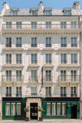 a large white building with green doors and windows at Hotel Monge in Paris
