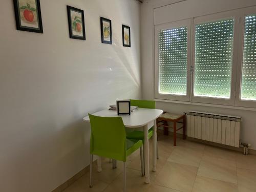a dining room with a white table and green chairs at Apartamento de 3 habitaciones en GIRONELLA - ALBERGA in Gironella