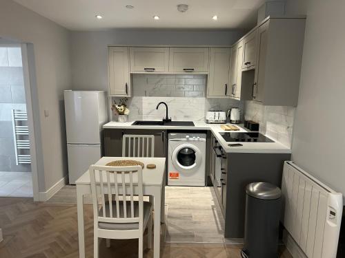 a kitchen with a stove and a sink and a dishwasher at The Loft in Merthyr Tydfil